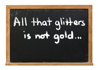 Obraz premium All that glitters is not gold written in white chalk on a black chalkboard isolated on white