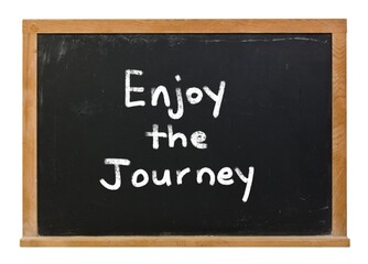 Enjoy the journey written in white chalk on a black chalkboard isolated on white