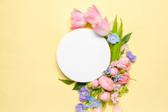 Composition with beautiful spring flowers and blank card on color background