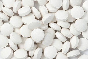 Heap of medicine white pills, antibiotic tablets, drugs. Pharmacy theme. Close-up, macro, top view