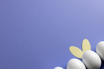 Image of row of white easter eggs with bunny ears and copy space on purple background