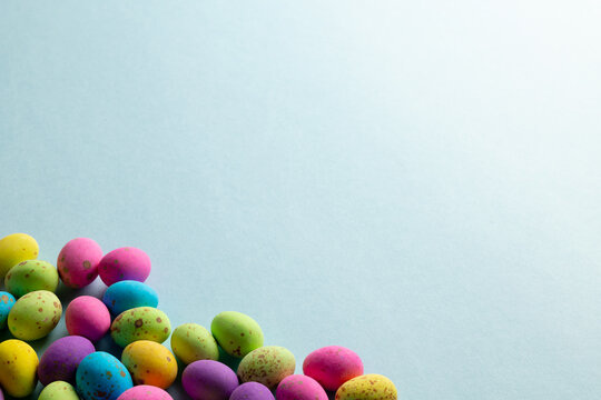 Image of multi coloured easter eggs with copy space on blue background