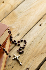 Image of close up of two holy bibles with rosary and copy space on wooden background