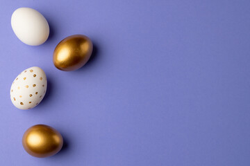 Image of multi coloured easter eggs and copy space on purple background