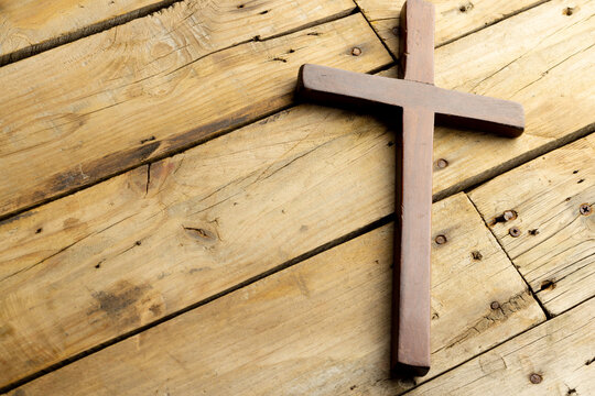 Image of close up of cross and copy space on wooden background