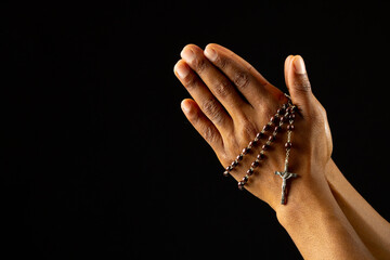 Fototapeta premium Image of close up of hands of african american woman praying with rosary