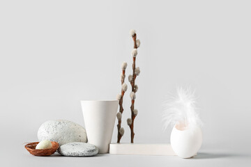 Fototapeta na wymiar Composition with podiums, willow branches, egg shell and stones on white background