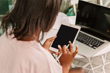 Mock up african american woman hipster sitting outside street cafe using laptop tablet pc gadget, working typing message. Young entrepreneur female freelancer high school student businesswoman
