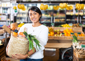 Portrait of happy woman with bag of groceries in supermarket - obrazy, fototapety, plakaty