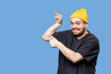 an caucasian and emotional man pointing to free space is captured while looking at the camera, in a...