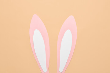 Paper bunny ears on beige background