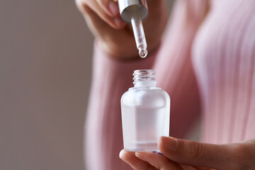 Dropping a drop of essential oil into a bottle