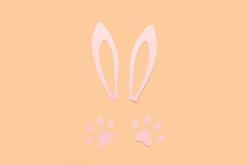 Paper bunny ears and paws on beige background
