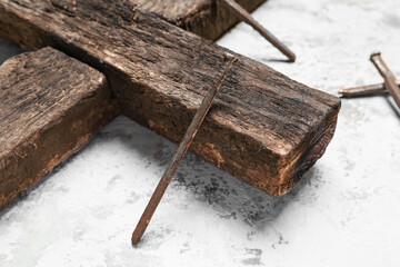 Wooden cross with nails on grunge background, closeup. Good Friday concept