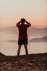 Fototapeta premium An athlete rests on top of a mountain after exhausting running training.