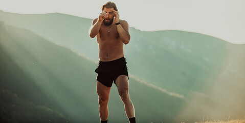 Man boxing with shadow exercising at sunset outdoor. Port victory healthy lifestyle concept. Man...