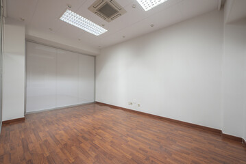 An empty office with technical ceilings that support an air conditioner
