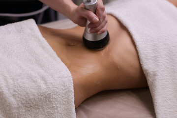 procedure removing cellulite on female abdomen, cavitation belly massage. Ultrasonic massage for...