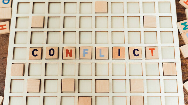 Conflict word made from scrabble game tiles - Scrabble letters on the game board. High quality photo