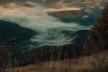 Obraz na płótnie Canvas Mountain range with visible silhouettes through the morning colorful fog