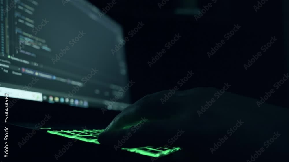 Wall mural male programmer writes program code on a laptop. close-up. night.