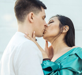 Young couple in love of different nationality hugging and kissingnear river. Asian woman and european man.