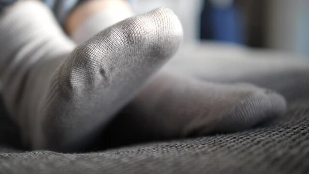 Cozy house, close-up of the legs of a resting woman in socks on the sofa.