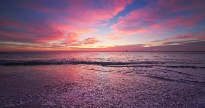 Colorful sky clouds and scenic sunrise over the sea waves and beach shore, 4k video
