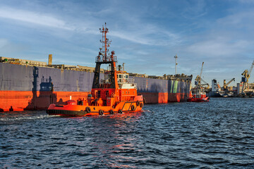 Fototapeta premium Port of Gdansk, Baltic Sea, A large bulk carrier with a displacement of 81,703 t DWT, built in 2019, enters the port with the assistance of tugboats, the ship is 228.99 meters long, 32 meters wide, an