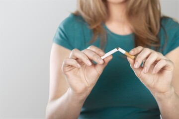 Stop smoking concept, young woman broken cigarette