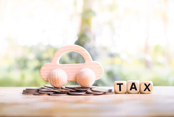 Wooden toy car on stack of coins and wooden blocks with the word TAX. The concept of paying tax for car. Car taxes.