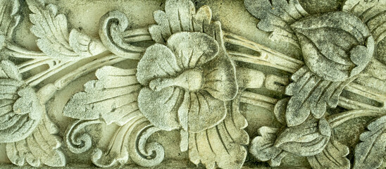 Fototapeta na wymiar Carved concrete flower design with mildew and stains