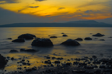 Rocks on the beach during sunrise in Banyuwangi, Indonesia. Long exposure photography. Defocused.