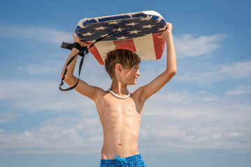 Youth Child Preteen Boy Standing on Beach Holding A Boogie Board Over His Head