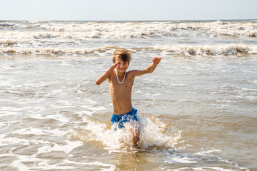 Youth Child Preteen Boy Running Into the Waves and Ocean Water at the Sunny Beach