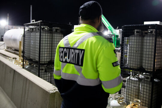 Security guard patrolling commercial storage area at night
