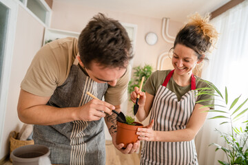 Couple caucasian man and woman wife and husband planting flowers together taking care of home plants real people domestic life family gardening concept copy space