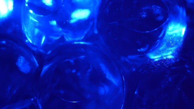 Water color gel balls. Super macro bubbles slow motion. Bubbles of water. Liquid cream gel transparent cosmetic texture sample with bubbles. Background with hydrogel balls with glitter.
