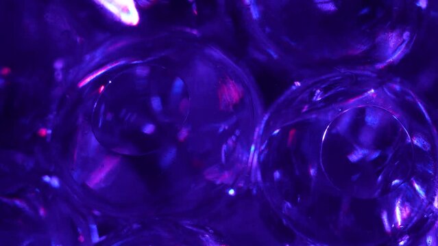 Water color gel balls. Super macro bubbles slow motion. Bubbles of water. Liquid cream gel transparent cosmetic texture sample with bubbles. Background with hydrogel balls with glitter.