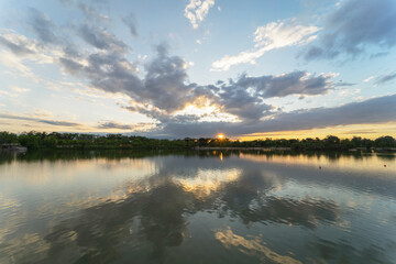 Beautiful Sunset.Sun,Lake.Sunrise Landscape.Beauty in Nature.Blue Sky. Amazing colorful clouds. Reflections on water. Magical artistic wallpaper. Orange background in Polvoranca park. Leganes. Spain