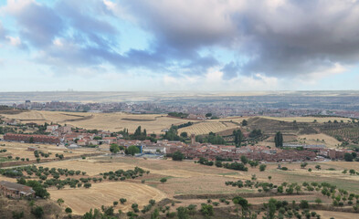 Yellow field landscape in summer from the town of iriepal in the foreground, the city of Guadalajara in the middle plane and in the background the 4 towers of Madrid.