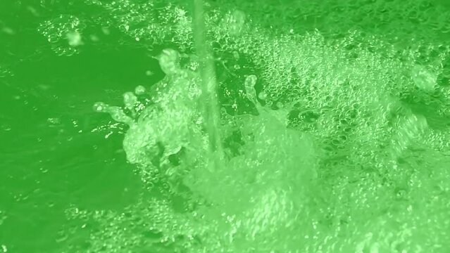 green waterfall drops closeup, transparent water in motion