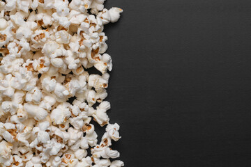popcorn scattered on black table with space for text