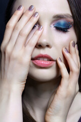 Beautiful brunette with blue eye shadow make up and rhinestones. Eyes closed.