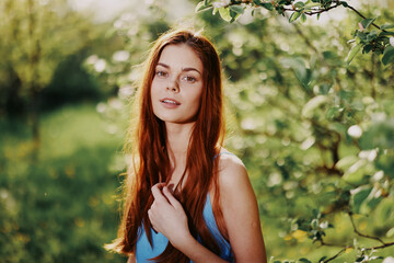 Elegant beautiful young woman portrait smile with teeth in the park in nature in the sunset light of summer