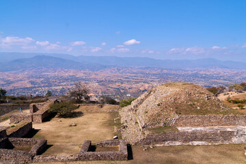 Naklejka na ściany i meble Ruinas de Monte Albán en Oaxaca, hermosos paisajes en la cima de una montaña con arboles antiguos cielo azul y caminos polvorientos