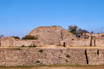 Fototapeta na wymiar Ruinas de Monte Albán en Oaxaca, hermosos paisajes en la cima de una montaña con arboles antiguos cielo azul y caminos polvorientos