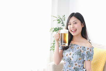 自宅でビールを飲む女性