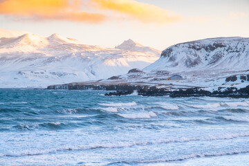 Pure blue ocean water at sunset, Ocean coastline with mountains, Winter landscape with snow, clouds and stormy sea