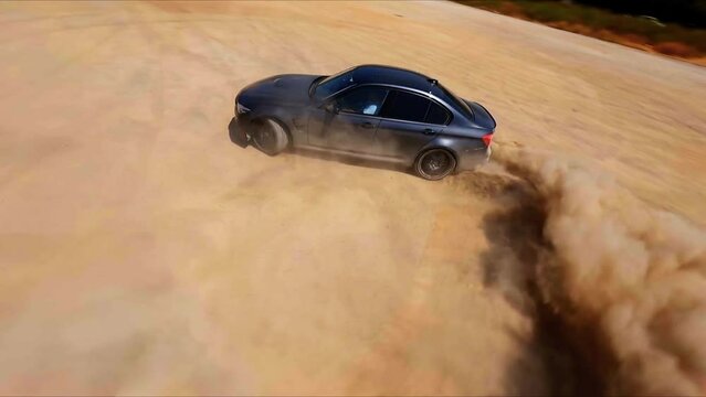 Epic aerial FPV following a black sports car drifting in the desert sand.